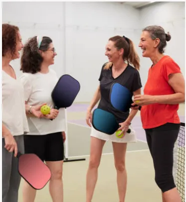 Players socializing with pickleball paddles at FitCourts